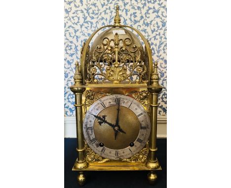 A large Lantern Style clock contained in a brass case with cast ""suns"" on sides. Large bell on top and bell on back of move