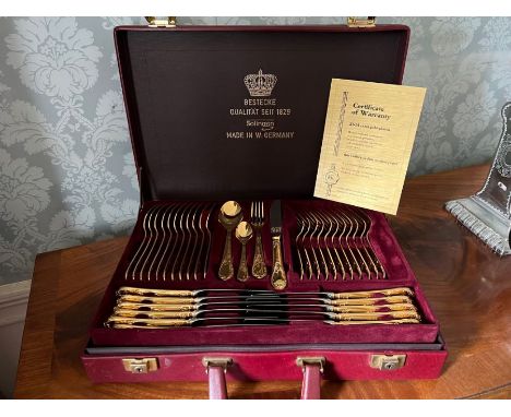 A complete Solingen 23-24 carat gold plated cutlery service for 12 settings to include dessert forks and serving utensils. In