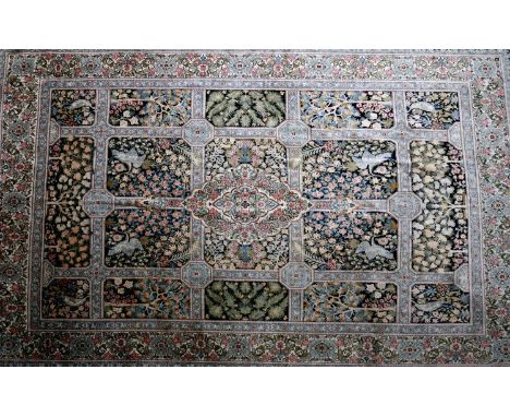 A 20th century Persian carpet, with central floral medallion, surrounded by tiles having floral and bird motifs on a black an