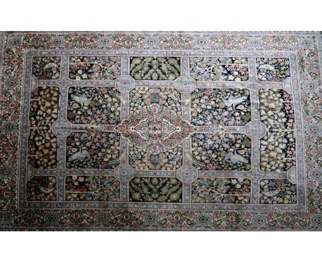 A 20th century Persian carpet, with central floral medallion, surrounded by tiles having floral and bird motifs on a black an