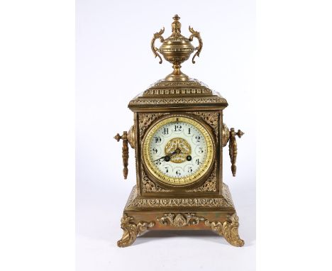 French gilt brass striking mantle clock of architectural form with urn finial, the white enamel dial with Arabic numerals, th