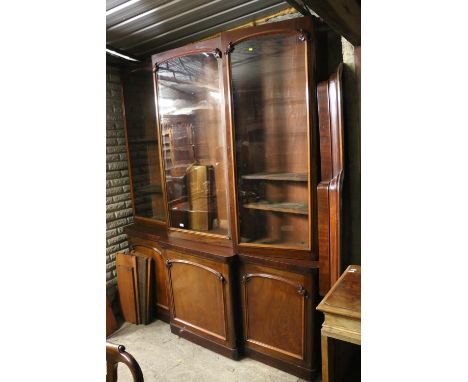 Victorian mahogany bookcase, the inverted break front top with three glazed doors enclosing adjustable shelves, the base fitt