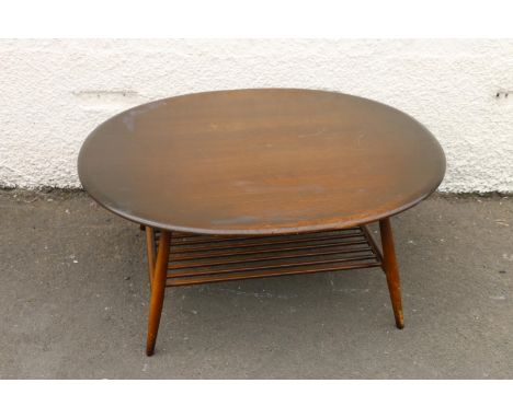 Ercol dark elm top oval coffee table with turned supports united by spindle lower tier, 44cm high x 100cm wide x 83cm deep.