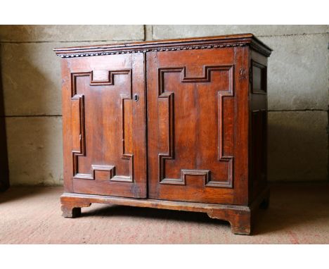 18th century French oak cabinet, with rectangular top, moulded edge, dentil cornice over two geometric panel doors enclosing 