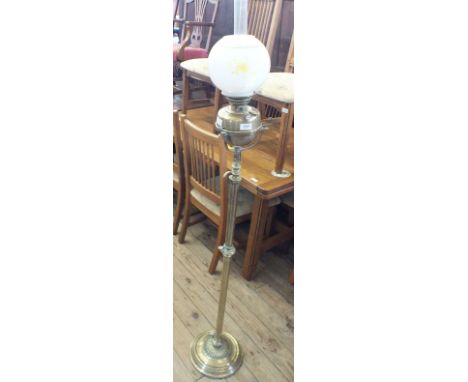 A floor standing adjustable brass oil lamp