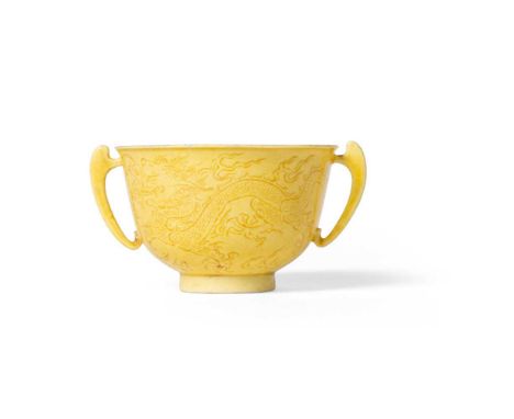 INCISED YELLOW-GLAZED 'DRAGON' HANDLED CUP KANGXI MARK, 19TH-20TH CENTURY   十九至二十世紀 康熙款 黃釉暗刻龍紋雙耳杯 delicately potted, resting 