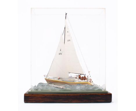 A small scale model of a GK 24 yacht 'Tern' No K370: fully rugged  with crew on deck, on a waterline base within a perspex ca