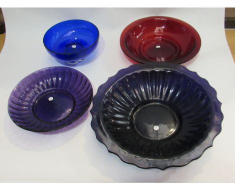 Three Victorian glass bowls, one cranberry, one ruby, one amethyst, largest 39cm diameter. Plus, a modern blue glass bowl on 