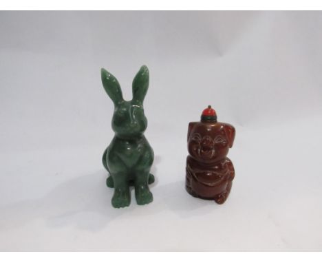 An amber snuff bottle in the form of a pig and a jade rabbit figure