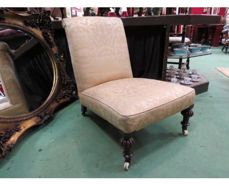 Circa 1840 a walnut open armchair on turned and melon fluted legs with white ceramic castors