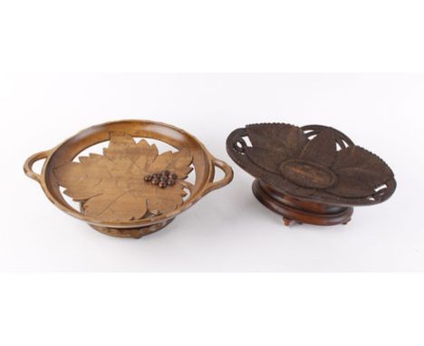 An early 20th century Black Forest-type carved musical fruit bowl, playing on two airs, w. 24.5 cm, together with another mus