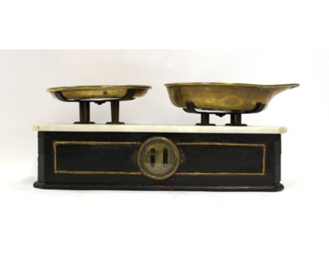 A pair of Victorian scales, the brass trays marked 'Parnell & Sons', over a marble surface and ebonised base, 40 cm