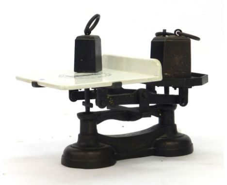 A set of early 20th century cast metal balance scales, the ceramic plate advertising Young Son & Marlow, together with two 7l