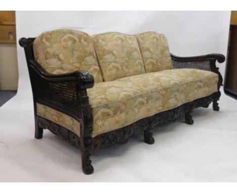 A 20th century stained beech and double bergere three seater sofa of serpentine form on scrolled feet CONDITION REPORT: Reuph