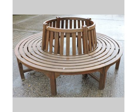 A circular teak bench, in four sections, with label for Chic Teak, 205cm diameter overall