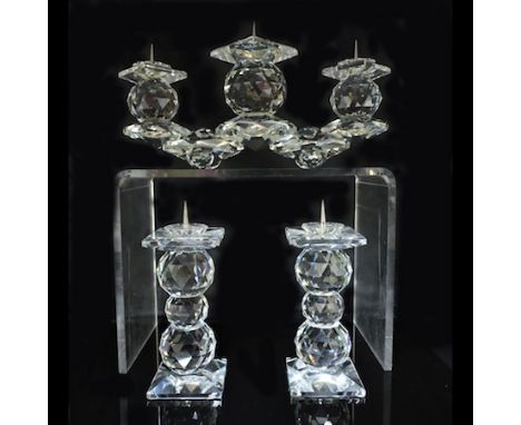 A pair of Swarovski candlesticks, boxed, together with a Swarovski crystal triple candlestick, 12cm tall