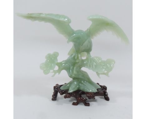 A jade coloured hardstone model of an eagle, with a carved hardwood stand, 25cm tall overall, boxed