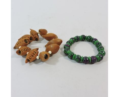 A Chinese carved wooden bracelet, together with a jade coloured bracelet