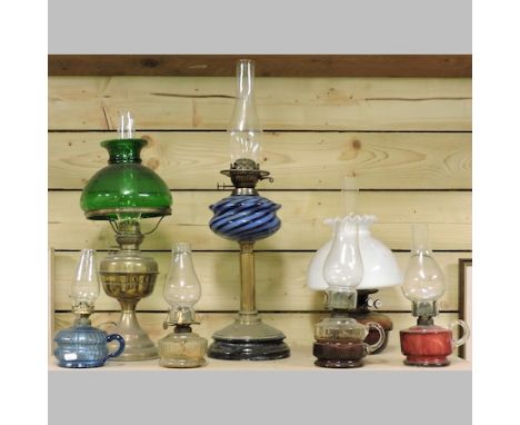A Victorian brass oil lamp, with a blue striped glass reservoir, 65cm tall overall, together with six smaller and a hanging a