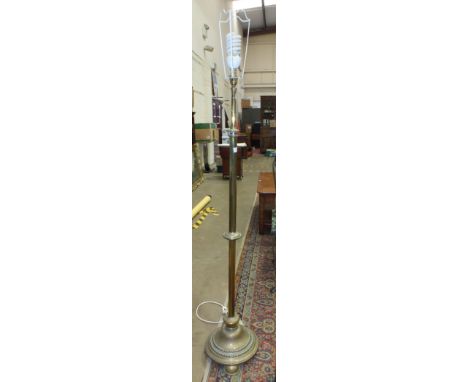 A late-19th/early-20th century brass adjustable lamp standard, on circular base and three feet, (converted to electricity). 