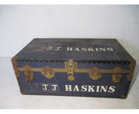 A vintage metal bound trunk, marked J.J. Haskins.