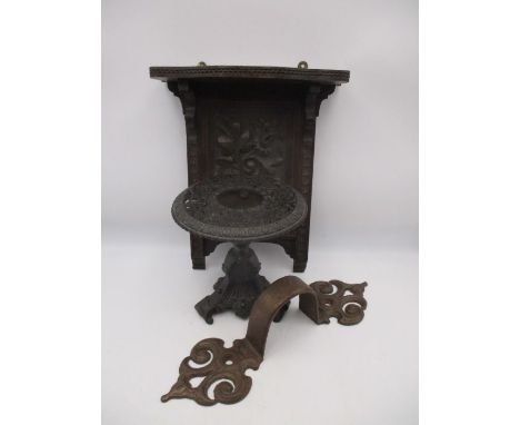 An oversized cast door handle, carved oak shelf and a cast iron candlestick