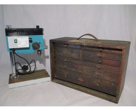 A vintage engineers toolbox with a small selection of tools, along with a digital readout micro pillar drill.