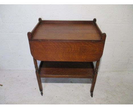 A vintage oak tea trolley with single leaf