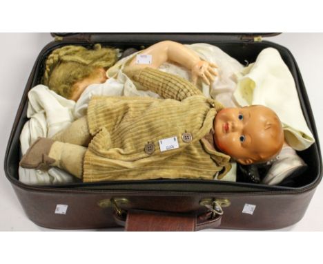 A Black doll by 'Rosebud', with a composite doll, and a ceramic head doll, in suitcase