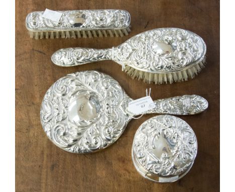 A matched Elizabeth II four piece dressing table set, comprising hand mirror, two brushes and a trinket box, embossed Victori