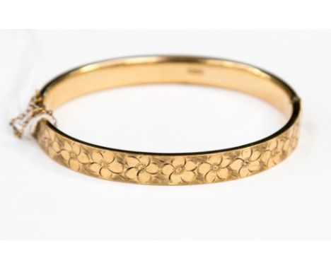 A 9ct gold hinged bangle, flower head engraved design, 11.3 grams 
