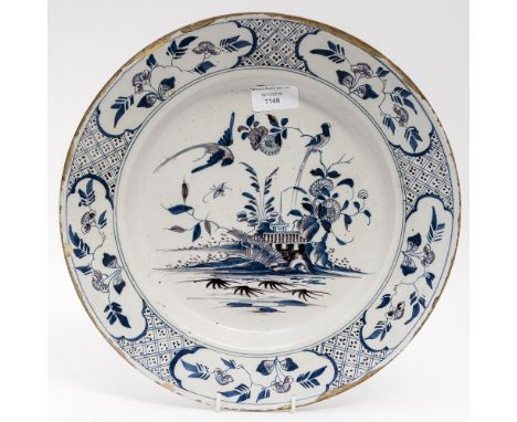 A mid 18th Century Delftware plate, probably English circa 1750, the border with geometric and floral panels, the centre with