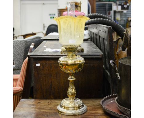 A brass oil lamp with glass shade, stamped with an Art Nouveau style decoration, 63 cm high approx 