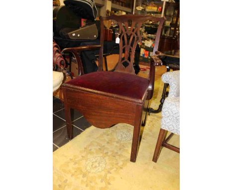 A George III mahogany commode chair, in the manner of Thomas Chippendale, the back with a shaped and pierced back splat, the 