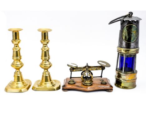 A set of postal scales, a pair of 19th Century brass candlesticks and an Ackroyd & Best projector lamp (4)