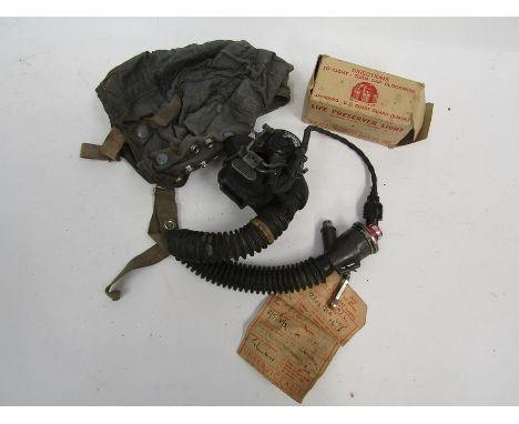 A post war RAF flying helmet with oxygen mask and survival lamp
