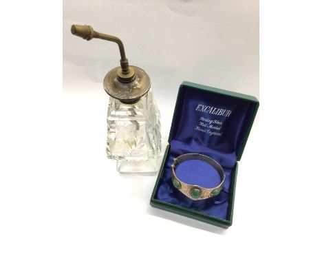 Silver Excalibur bangle with three green stones, together with a silver topped glass perfume bottle