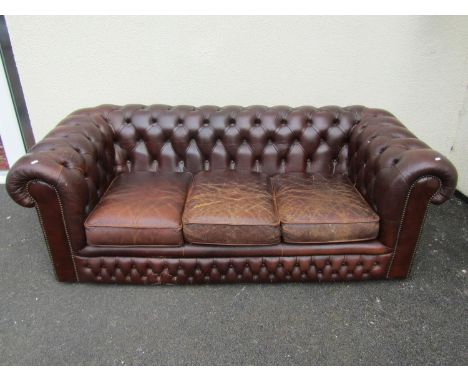 A brown leather chesterfield three seat sofa, with rolled and buttoned arms and back