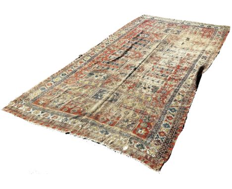 An old Sumak carpet, very worn and faded, repeating geometric patterns, 300cm x 165cm approximately