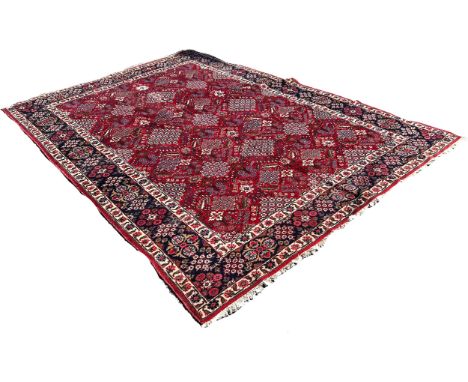 A Tabriz carpet with a repeating floral geometric pattern in tones of red and blue 330cm x 250cm approximately 