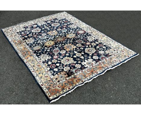A Serapi type carpet with a large floral design on a blue ground, 220cm x 160cm.