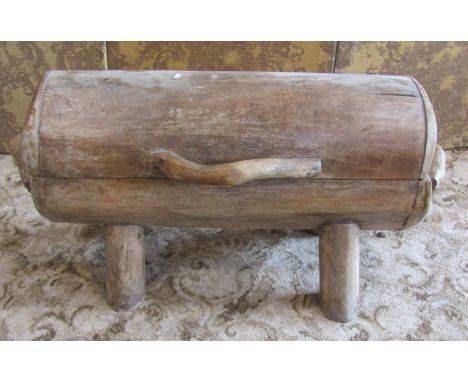 An unusual rustic / primitive style timber log trunk, with hinged cover, raised on tapering supports, 54cm high, 95 x 35cm.