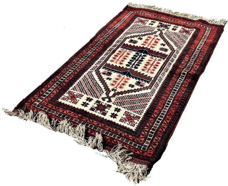 A Kazak type carpet with an elongated central panel on a cream ground, 180cm x 110cm approximately