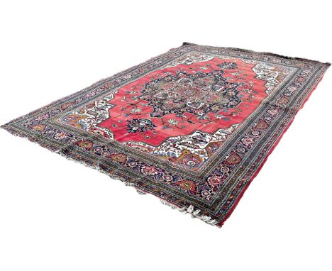 A Middle  Eastern carpet with an expansive stylised floral central medallion on a pink ground, 390cm x 275cm approximately
