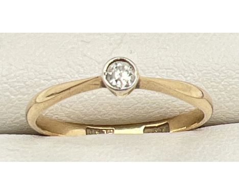 A vintage 18ct gold and platinum bezel set 0.07ct diamond solitaire ring. Gold marks to inside of band, Size O. Total weight 