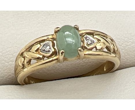 A 9ct gold hearts and kisses style band ring set with an oval of green jade and 2 small diamonds. Full hallmarks to inside of