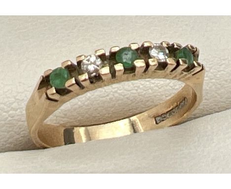 A 9ct gold emerald and diamond half eternity ring. Set with 5 stones, alternating emeralds and diamonds. Full hallmarks to in