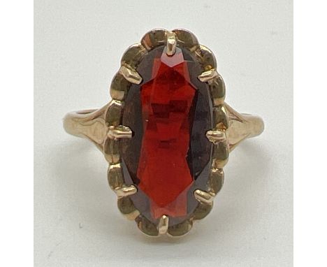 A vintage 9ct gold garnet dress ring. A large oval cut claw set garnet set in a decorative pierced work mount. Full hallmarks