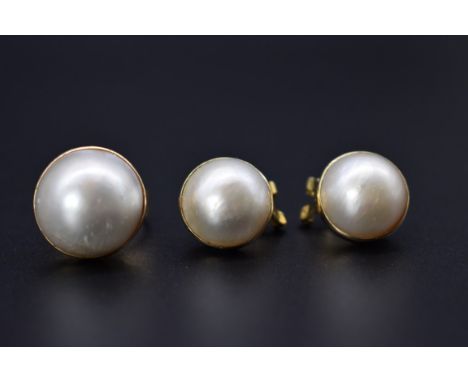 A yellow metal ring, set pearl and a matching pair of ear clips, stamped 14k. 