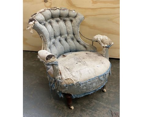 A 19th century button back bedroom chair, in need of reupholstery with iron framed back, open arms, on turned legs and cerami